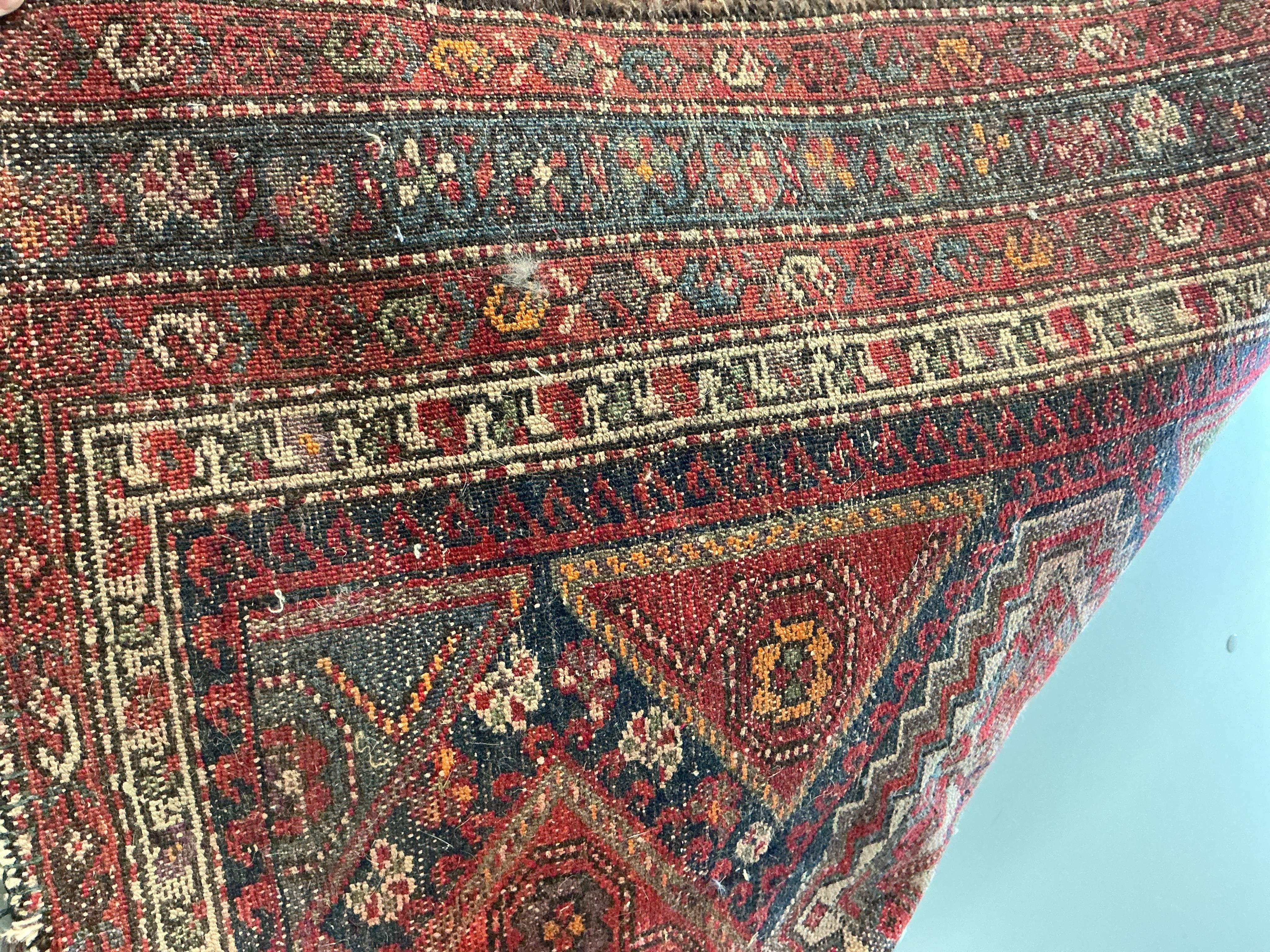 An antique Caucasian blue ground runner and a Caucasian red ground rug (heavily worn), larger 336 x 87cm